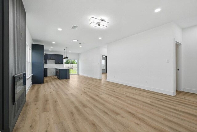3923 Le May Ave, Dallas, TX 75216 - unfurnished living room with recessed lighting, light wood-style flooring, and baseboards