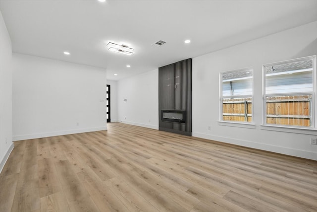 3923 Le May Ave, Dallas, TX 75216 - unfurnished living room with recessed lighting, light wood-style flooring, a large fireplace, and baseboards