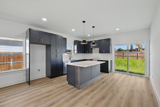 3923 Le May Ave, Dallas, TX 75216 - kitchen featuring dishwasher, a kitchen island, a sink, light countertops, and light wood-type flooring