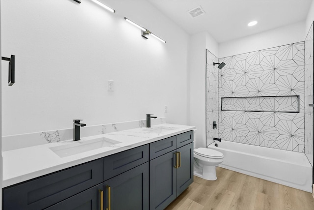 3923 Le May Ave, Dallas, TX 75216 - full bathroom featuring toilet, washtub / shower combination, wood finished floors, double vanity, and recessed lighting