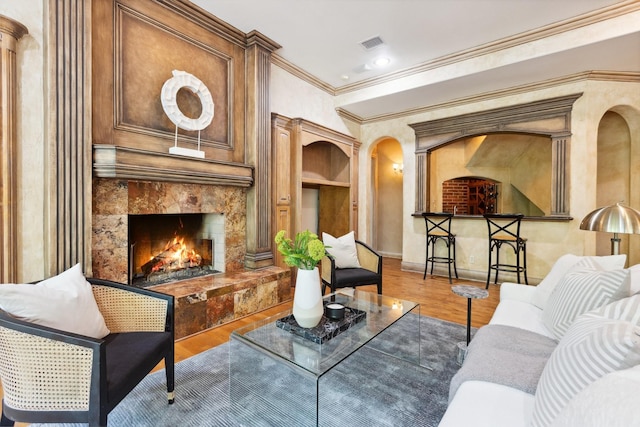 9922 Lakeway Ct, Dallas, TX 75230 - living room featuring a high end fireplace, wood finished floors, ornamental molding, baseboards, and arched walkways