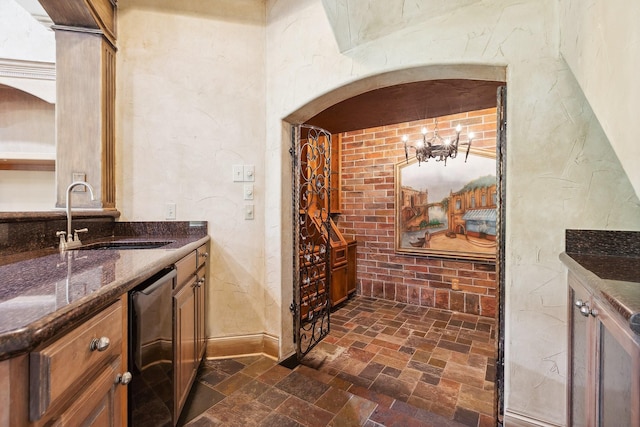 9922 Lakeway Ct, Dallas, TX 75230 - wine cellar featuring a sink, a chandelier, dark stone finish floors, arched walkways, and baseboards