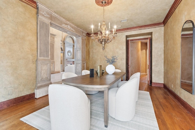 9922 Lakeway Ct, Dallas, TX 75230 - dining space with wood finished floors, a chandelier, ornamental molding, baseboards, and arched walkways