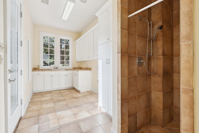 9922 Lakeway Ct, Dallas, TX 75230 - bathroom with tiled shower, vanity, baseboards, and tile patterned flooring