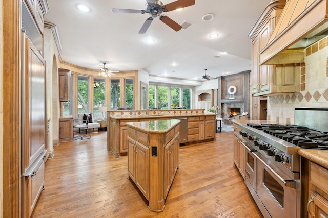 9922 Lakeway Ct, Dallas, TX 75230 - kitchen with stainless steel appliances, ceiling fan, a kitchen island, backsplash, and a sink