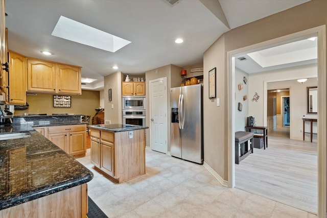 1405 Danube Ln, Plano, TX 75075 - kitchen featuring stainless steel appliances, light brown cabinets, a skylight, dark stone counters, and recessed lighting