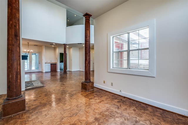 905 Liberty St, Dallas, TX 75204 - unfurnished living room featuring decorative columns, baseboards, a chandelier, and vaulted ceiling