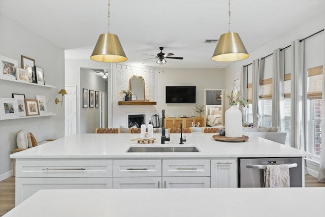 15429 Calico Ct, Frisco, TX 75035 - kitchen with a sink, stainless steel dishwasher, white cabinetry, a ceiling fan, and decorative light fixtures
