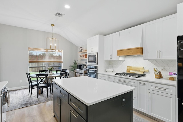 15429 Calico Ct, Frisco, TX 75035 - kitchen featuring stainless steel appliances, lofted ceiling, white cabinetry, backsplash, and a kitchen island