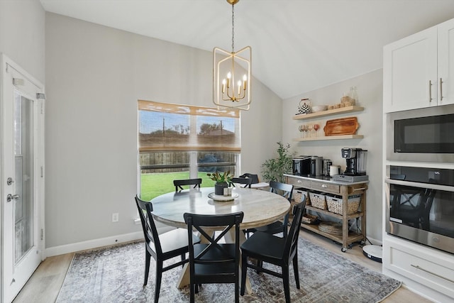 15429 Calico Ct, Frisco, TX 75035 - dining area with a chandelier, lofted ceiling, light wood-style flooring, and baseboards