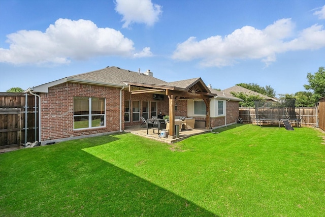 15429 Calico Ct, Frisco, TX 75035 - back of house with a trampoline, a patio, brick siding, and a chimney