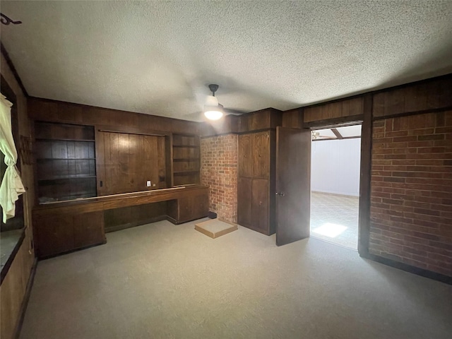 310 Lancashire Dr, Bossier City, LA 71111 - unfurnished bedroom with wood walls, a textured ceiling, and a ceiling fan