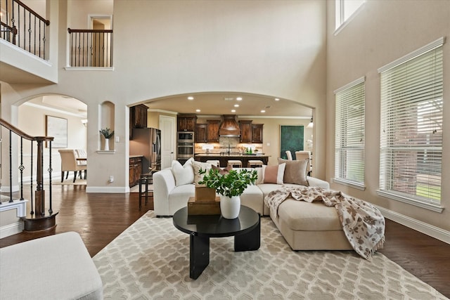 14759 Huffman Ln, Frisco, TX 75035 - living area featuring arched walkways, a high ceiling, wood finished floors, and baseboards