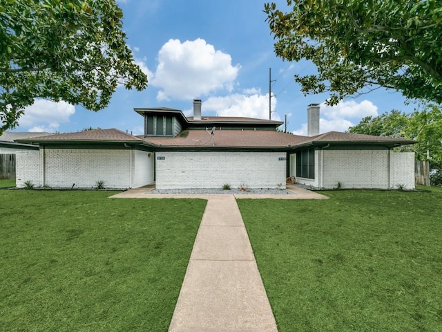 100 Trellis Pl Unit 102, Richardson, TX 75081 - back of house featuring a chimney, a lawn, and brick siding