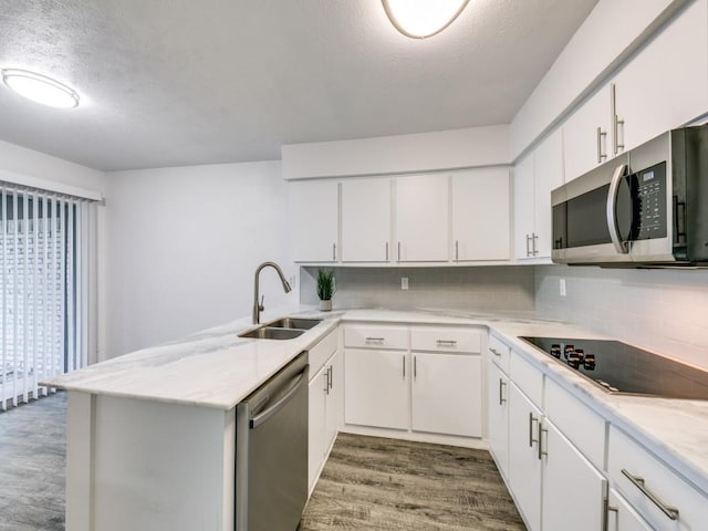 100 Trellis Pl Unit 102, Richardson, TX 75081 - kitchen with stainless steel appliances, a sink, dark wood-style flooring, a peninsula, and light countertops