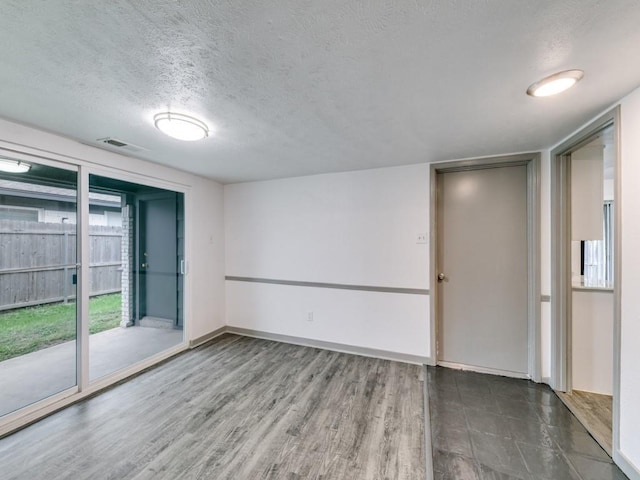 100 Trellis Pl Unit 102, Richardson, TX 75081 - spare room featuring a textured ceiling, baseboards, and wood finished floors