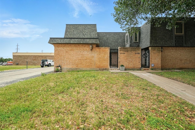 2729 Caton Pl, Abilene, TX 79605 - view of front facade with mansard roof, roof with shingles, a gate, and brick siding
