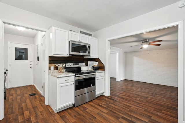 2729 Caton Pl, Abilene, TX 79605 - kitchen featuring stainless steel appliances, dark wood-style floors, brick wall, a ceiling fan, and white cabinets