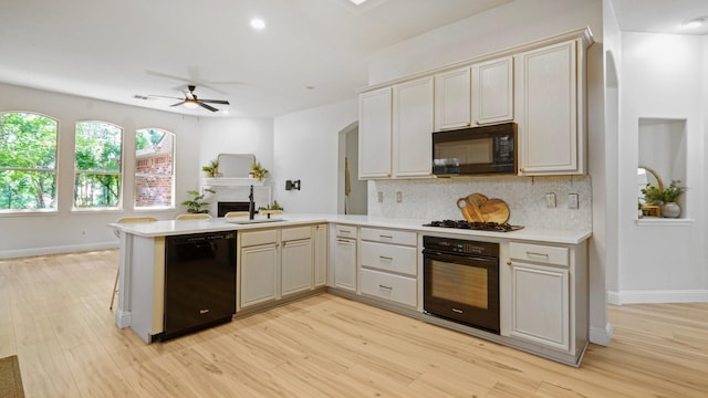 713 N Jordan Rd, Mckinney, TX 75071 - kitchen featuring black appliances, a sink, a peninsula, light countertops, and light wood-style floors