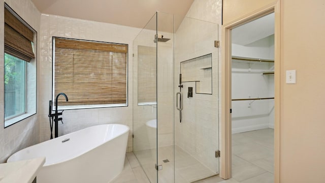 713 N Jordan Rd, Mckinney, TX 75071 - full bathroom featuring a freestanding bath, a shower stall, a spacious closet, tile patterned flooring, and tile walls