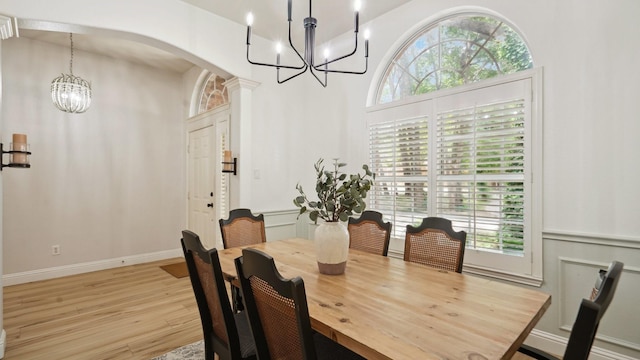 713 N Jordan Rd, Mckinney, TX 75071 - dining area featuring a chandelier, arched walkways, light wood-style flooring, and plenty of natural light