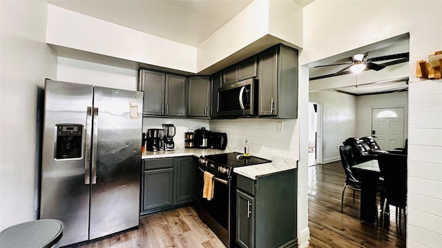 3030 Warren Ave, Dallas, TX 75215 - kitchen featuring appliances with stainless steel finishes, light wood-type flooring, a ceiling fan, and backsplash