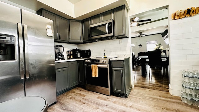 3030 Warren Ave, Dallas, TX 75215 - kitchen with appliances with stainless steel finishes, ceiling fan, light wood-type flooring, tasteful backsplash, and gray cabinets