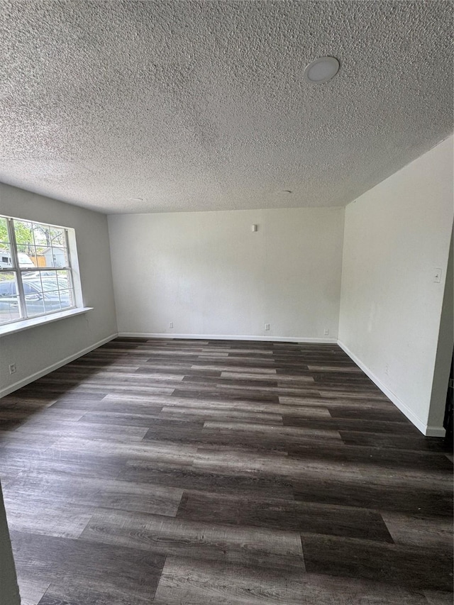 2441 Lindale Ln, Mesquite, TX 75149 - unfurnished room with a textured ceiling, dark wood-type flooring, and baseboards