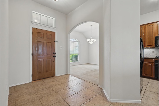 209 Lariat Dr, Fate, TX 75087 - foyer featuring arched walkways, a chandelier, light tile patterned flooring, baseboards, and vaulted ceiling