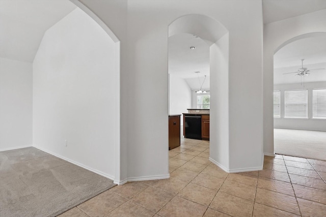 209 Lariat Dr, Fate, TX 75087 - hallway featuring arched walkways, light colored carpet, light tile patterned floors, and baseboards