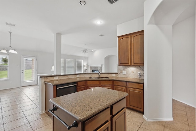 209 Lariat Dr, Fate, TX 75087 - kitchen featuring dishwashing machine, a sink, ceiling fan, a fireplace, and a peninsula