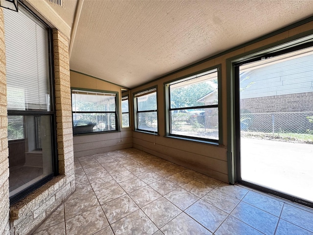 1050 35th St NE, Paris, TX 75462 - unfurnished sunroom featuring vaulted ceiling, a textured ceiling, and tile patterned floors