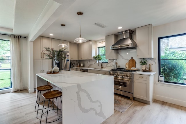 8023 Moss Meadows Dr, Dallas, TX 75231 - kitchen featuring appliances with stainless steel finishes, wall chimney range hood, a sink, plenty of natural light, and recessed lighting