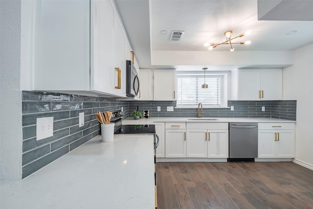 1112 Seabrook Dr, Plano, TX 75023 - kitchen featuring appliances with stainless steel finishes, a sink, white cabinets, and decorative backsplash