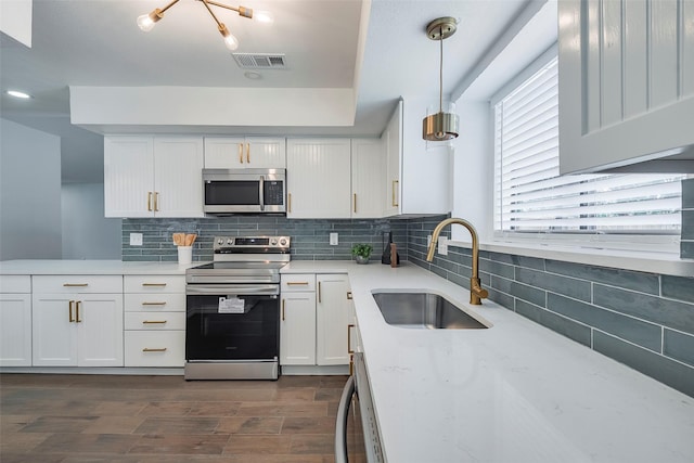 1112 Seabrook Dr, Plano, TX 75023 - kitchen featuring stainless steel appliances, a sink, tasteful backsplash, white cabinetry, and dark wood-style flooring