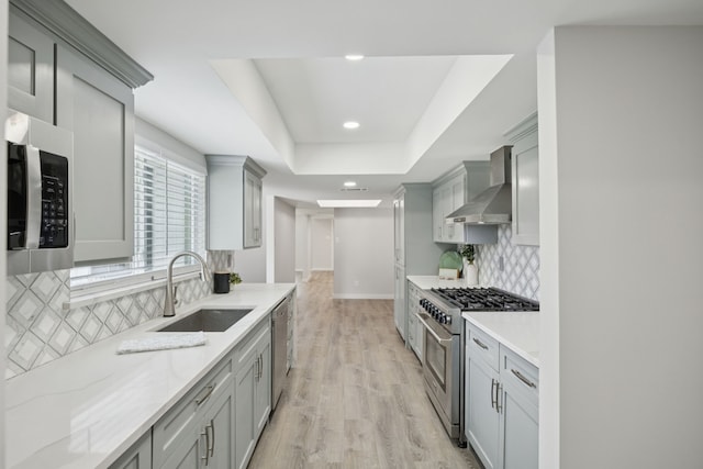1629 Mesquite Trl, Plano, TX 75023 - kitchen with stainless steel appliances, wall chimney exhaust hood, a sink, gray cabinets, and light stone countertops