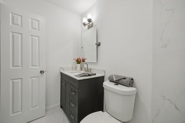 1629 Mesquite Trl, Plano, TX 75023 - bathroom featuring marble look tiles, double vanity, toilet, and baseboards