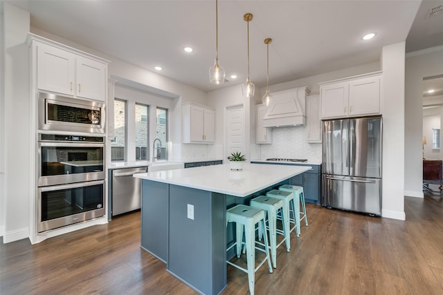 1302 Middleton Dr, Rockwall, TX 75087 - kitchen with appliances with stainless steel finishes, custom exhaust hood, white cabinets, a kitchen island, and light countertops