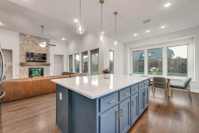 1302 Middleton Dr, Rockwall, TX 75087 - kitchen with plenty of natural light, wood finished floors, a brick fireplace, hanging light fixtures, and ornamental molding
