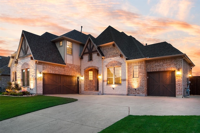 1302 Middleton Dr, Rockwall, TX 75087 - french country style house featuring concrete driveway, stone siding, brick siding, and a yard