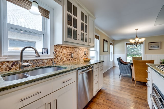 3817 Hilltop Rd, Fort Worth, TX 76109 - kitchen with stainless steel dishwasher, a sink, a chandelier, a wainscoted wall, and hanging light fixtures
