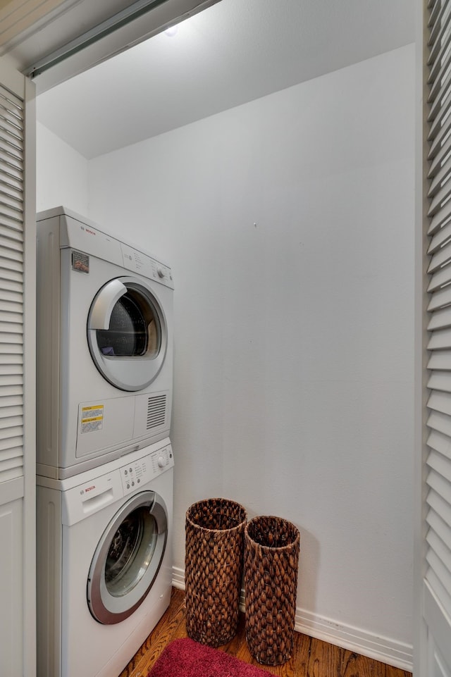 3817 Hilltop Rd, Fort Worth, TX 76109 - washroom featuring stacked washing machine and dryer, wood finished floors, and baseboards