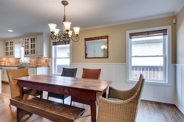 3817 Hilltop Rd, Fort Worth, TX 76109 - dining area featuring a chandelier, light wood-type flooring, wainscoting, ornamental molding, and a decorative wall