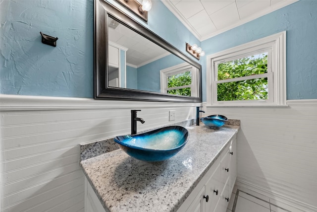 1403 E Texas Ave, Mart, TX 76664 - bathroom with vanity, crown molding, wainscoting, and tile patterned floors