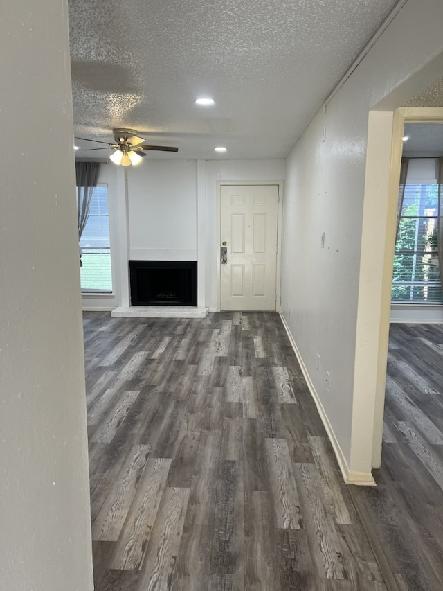 5502 Boca Raton Blvd Unit 329, Fort Worth, TX 76112 - unfurnished living room featuring a textured ceiling, ceiling fan, wood finished floors, and healthy amount of natural light