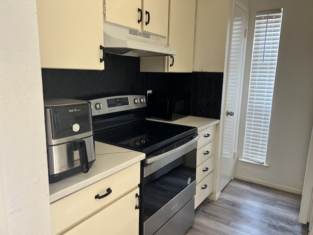 5502 Boca Raton Blvd Unit 329, Fort Worth, TX 76112 - kitchen featuring stainless steel electric stove, under cabinet range hood, black microwave, backsplash, and light countertops