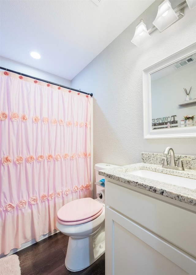1004 San Jacinto St, Terrell, TX 75160 - bathroom featuring vanity, toilet, wood finished floors, and a shower with shower curtain