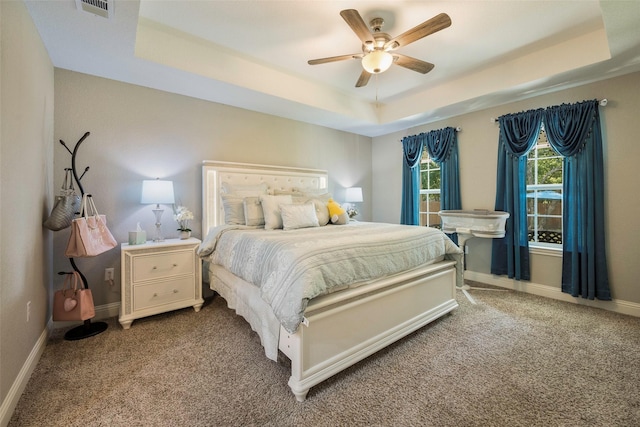 1004 San Jacinto St, Terrell, TX 75160 - carpeted bedroom with a raised ceiling, baseboards, and ceiling fan