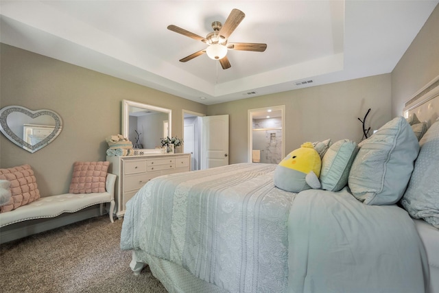 1004 San Jacinto St, Terrell, TX 75160 - carpeted bedroom with a raised ceiling, ceiling fan, and connected bathroom