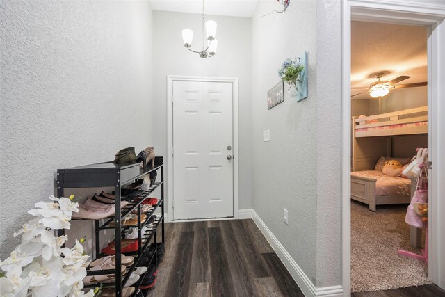 1004 San Jacinto St, Terrell, TX 75160 - foyer entrance featuring dark wood finished floors, a textured wall, a chandelier, and baseboards